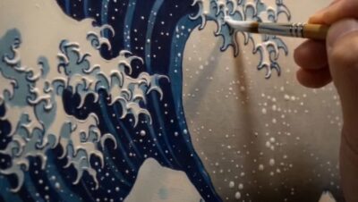 An oil-painting rendition of Hokusai's Great Wave on an easel — a giant Prussian-blue wave with curling white foam claws and a small Mount Fuji in the distance.