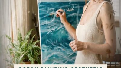 A woman in a cream swimsuit painting rolling turquoise ocean waves on a canvas at her easel in a cozy, plant-filled studio, gazing wistfully toward a bright window.