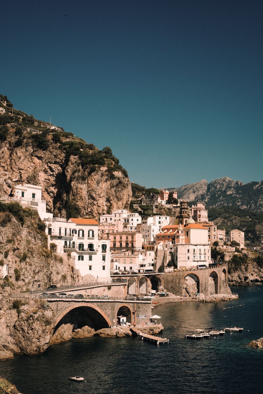 A pastel Amalfi Coast town tucked into the cliffs above the sea, with a church dome