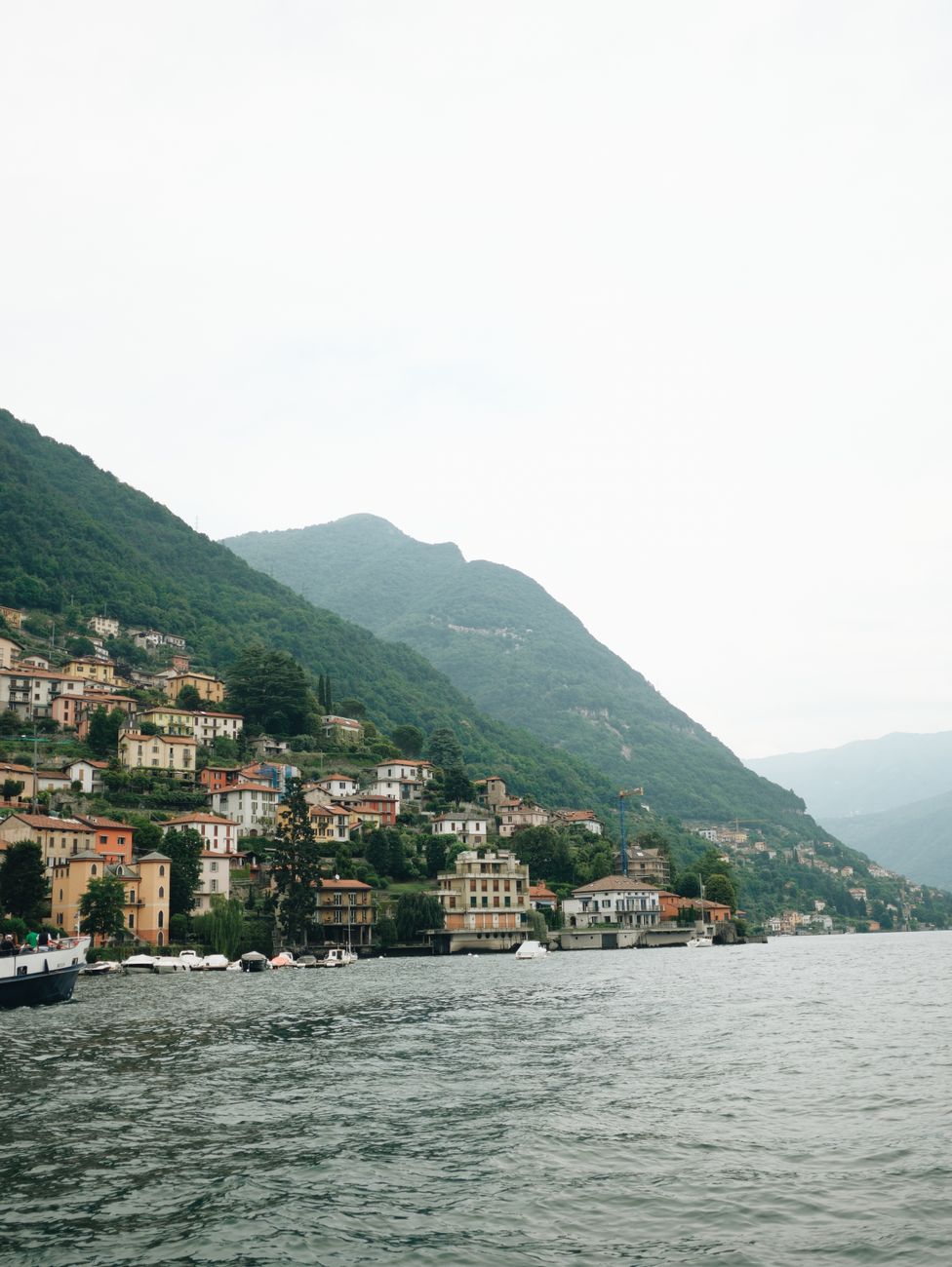 Varenna and Lake Como with green mountains rising behind the calm water