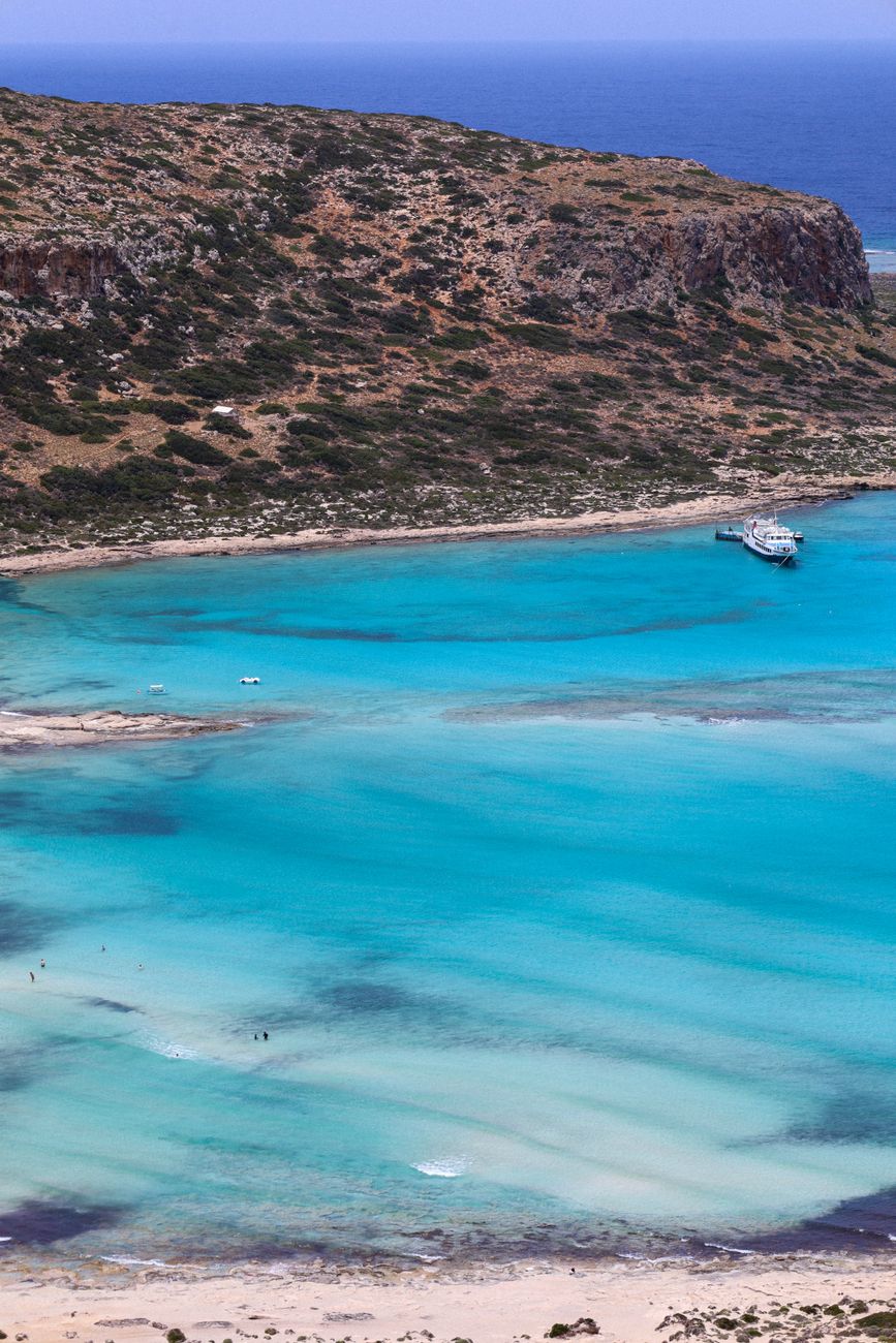 The turquoise Balos lagoon in Crete, pale sand splitting bands of mint and blue water