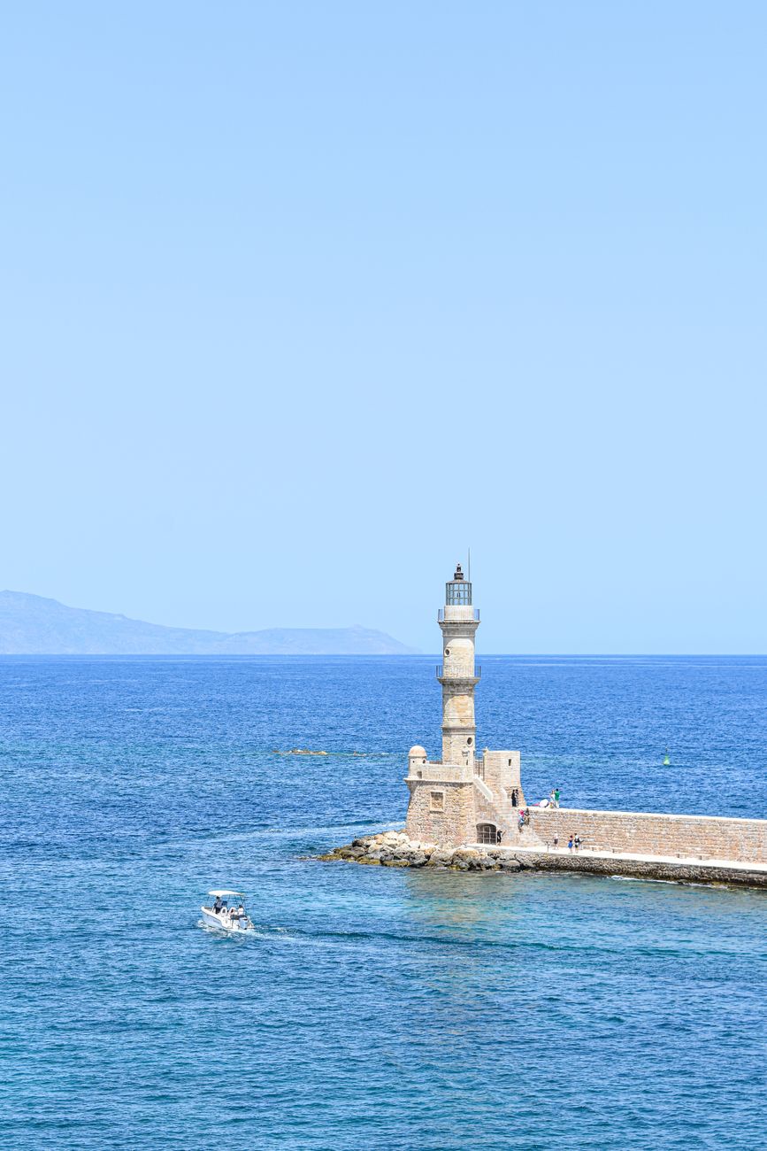 The Chania Venetian lighthouse standing in the calm sea at sunset, Crete