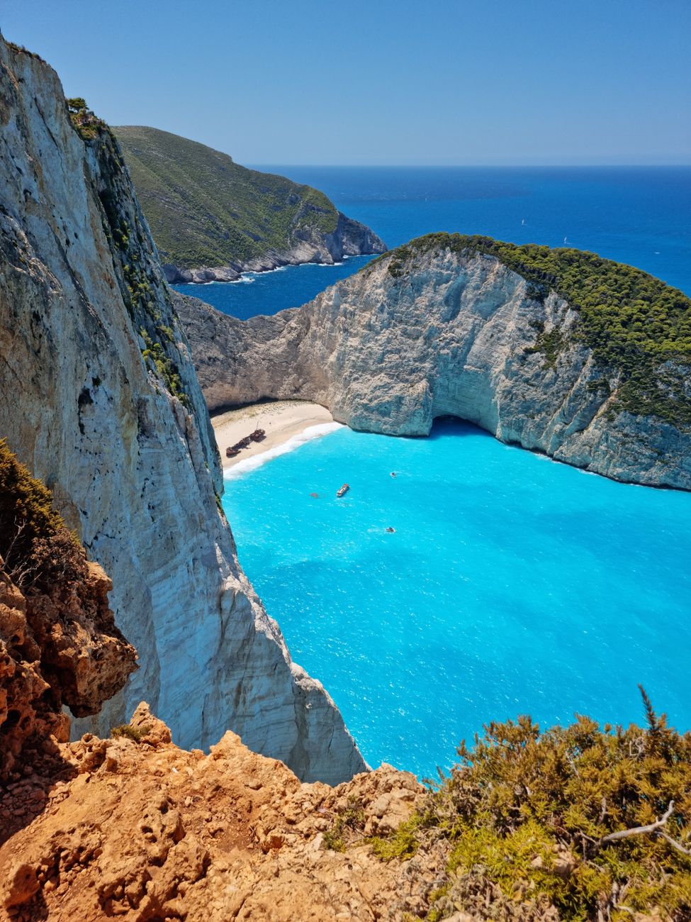Turquoise water in a sheltered Greek island cove framed by tall cliffs