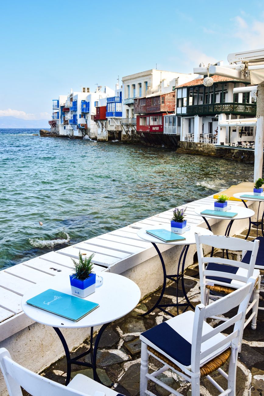 A waterfront café in Mykonos with tables right at the edge of the turquoise sea